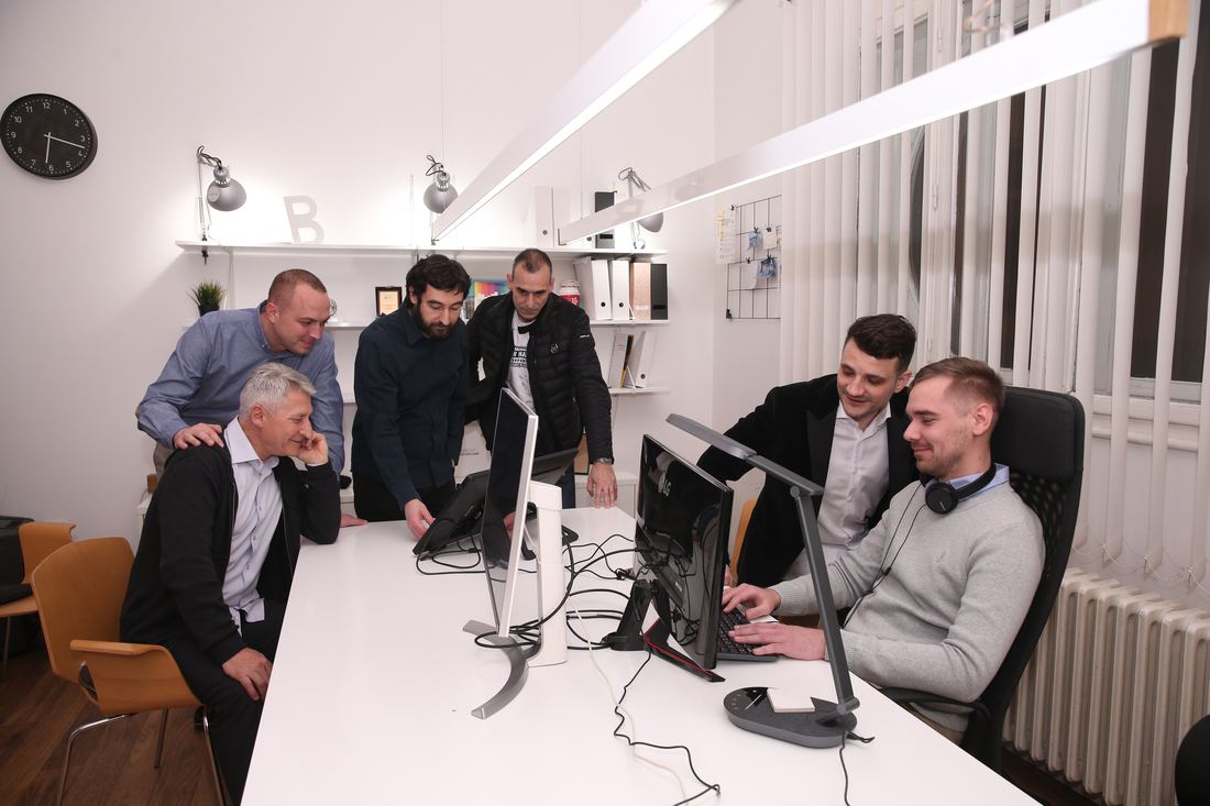 Engineers gathered around a workstation, reviewing a solution together